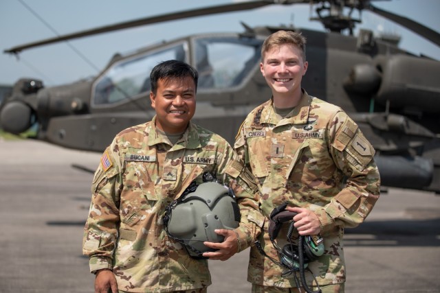 U.S. Army Cpl. Folkert-Champ S. Bucani, an attack helicopter repairer with Charlie Company “Ghost Riders,” 1st Battalion, 1st Aviation Regiment, 1st Combat Aviation Brigade, (left) poses with his platoon leader, 1st Lt. Cody James Clienbell, at Illesheim Army Airfield, Germany, July 22, 2021. Bucani was afforded the opportunity to fly on the AH-64 Apache in recognition of his outstanding service in maintaining the aircrafts’ readiness. 