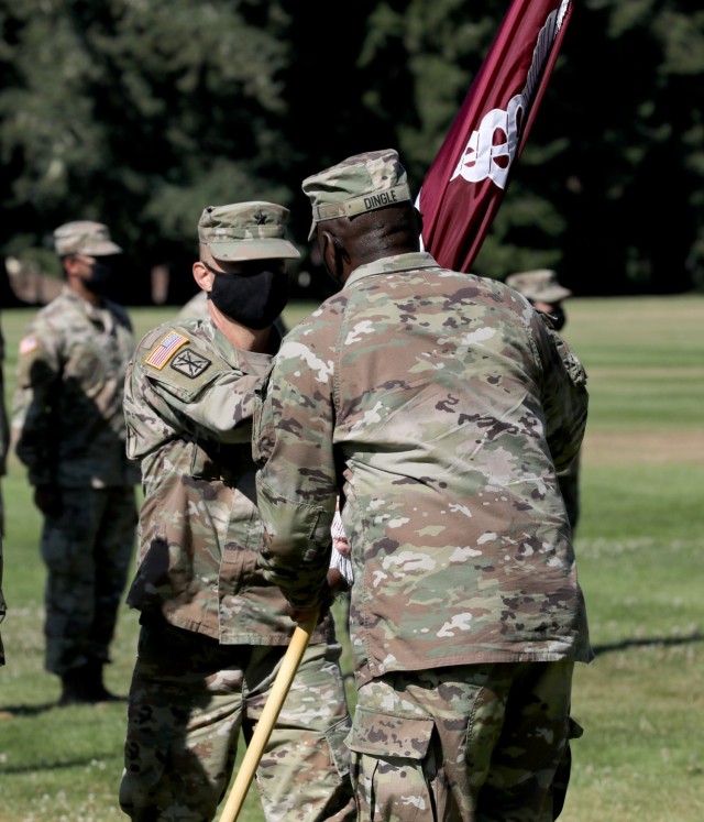 Brig. Gen. Jack M. Davis, left, outgoing commanding general of Regional Health Command-Pacific, passes the RHC-P colors to Lt. Gen. R. Scott Dingle, the Army Surgeon General and commanding general of U.S. Army Medical Command during Davis&#39;s change of command ceremony, July 26, 2021, at Joint Base Lewis-McChord, Washington.