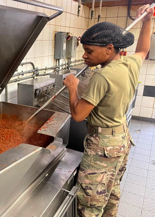 Army Reserve Sgt. Nicole Hall, who deployed to the U.S. Central Command area of operations to staff 1st Theater Sustainment Command's operational command post at Camp Arifjan, Kuwait, with the Indianapolis-based 310th Sustainment Command (Expeditionary), stirs chili at the North Dining Facility at Bagram Airfield, Afghanistan during her 29-day assignment there that ended July 2, 2021, when the DFAC closed. The sergeant, who Hall is one of four "Brickyard" Army culinary specialists, or 92G's, tasked to support the dining facility that served hot meals to both Coalition and U.S. forces, deployed previously to Afghanistan with the 1st Engineer Battalion of the 555th Engineer Brigade from September 2012 to May 2013 at Forward Operating Base Shank. (Photo courtesy of Sgt. Nicole Hall)