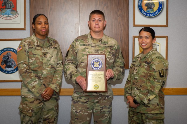 U.S. Army Sgt. Angelu Legaspi and Spc. Cierra Ellis, assigned to 55th Signal Company (Combat Camera), stand with U.S. Army Chief Warrant Officer 4 Adam Coltes, during the presentation of the Chief of Staff, Army, Supply Excellence Award Program...