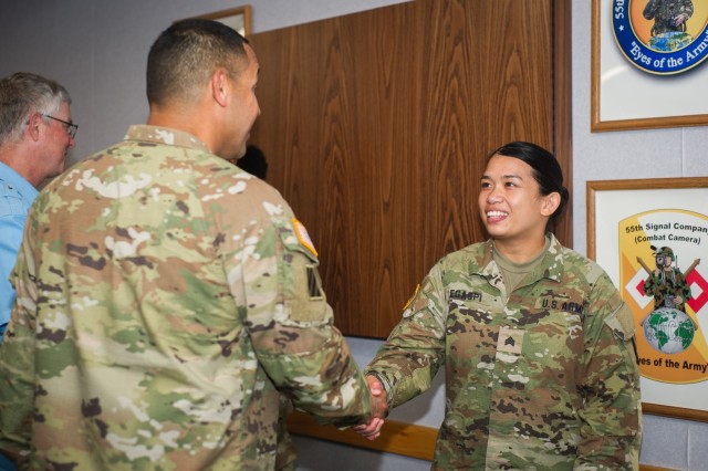 U.S. Army Sgt. Angelu Legaspi, assigned to 55th Signal Company (Combat Camera), shakes hands with Cmd. Sgt. Maj. Danny Rebolledo during the presentation of the Chief of Staff, Army, Supply Excellence Award Program (SEA) to 55th Signal Company...