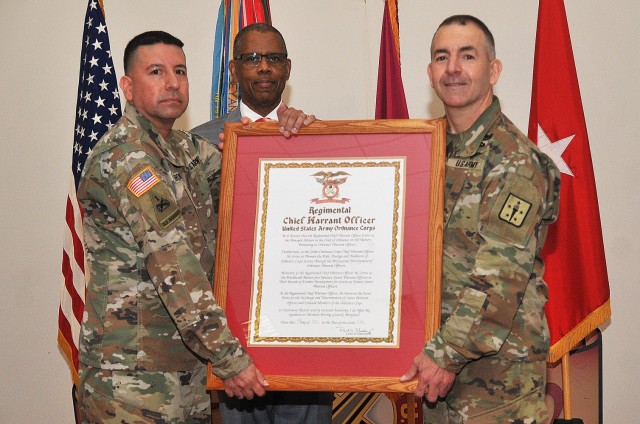 Chief Warrant Officer 5 Carlos H. Terrones, the new Ordnance Corps Chief Warrant Officer, holds the  Regimental Chief Warrant Officer Charter with Brig. Gen. Michael B. Lalor, Chief of Ordnance, and retired CW5 Harold DeBerry, honorary warrant...