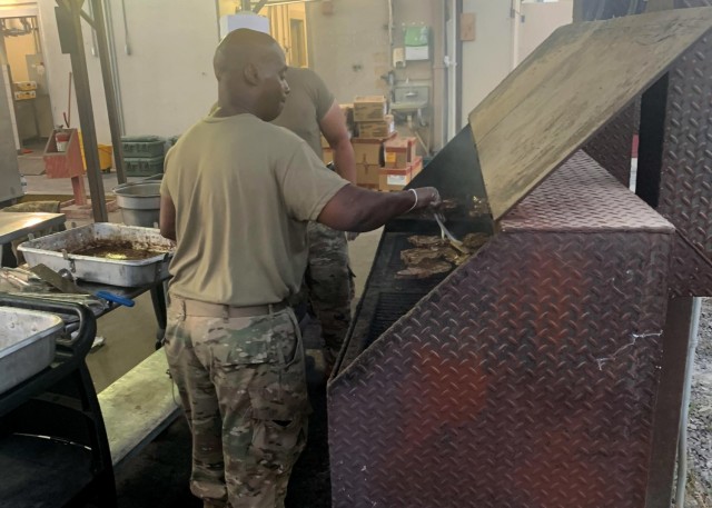 Army Reserve Master Sgt. Lloyd Cossey, who deployed to the U.S. Central Command area of operations at Camp Arifjan, Kuwait, with the Indianapolis-based 310th Sustainment Command (Expeditionary), grills steaks at the North Dining Facility at Bagram...