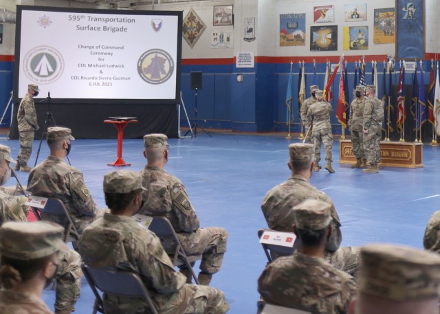 "Desert Knight" Soldiers of the 595th Transportation Brigade (SDDC) and guests watch as Maj. Gen. Heidi J. Hoyle, the commanding general of the Military Surface Deployment and Distribution Command, passes the brigade's colors to Col. Ricardo L. Sierra-Guzman, the incoming commander at the July 6, 2021 change of command ceremony. Sierra-Guzman succeeds Col. Michael E. Ludwick, whose daughter Gracie, 14, recorded her singing the National Anthem for the ceremony. (U.S. Army photo Staff Sgt. Neil W. McCabe)