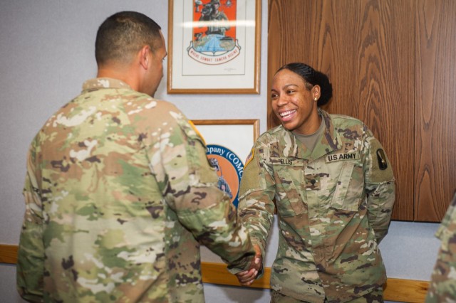 U.S. Army Spc. Cierra Ellis, assigned to 55th Signal Company (Combat Camera), shakes hands with Cmd. Sgt. Maj. Danny Robelledo during the presentation of the Chief of Staff, Army, Supply Excellence Award Program (SEA) to 55th Signal Company...
