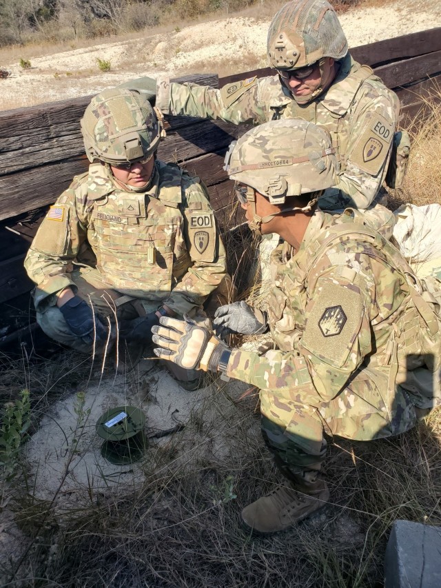 Spc. Christian J Feliciano-Roman (left) instructs Maj. Victoria S. Clemons, the operations officer from the 48th Chemical Brigade, and Staff Sgt. Luke J. Carter on demolition safety on Fort Hood, Texas.  U.S. Army photo by Capt. Jonathan A. Campbell.