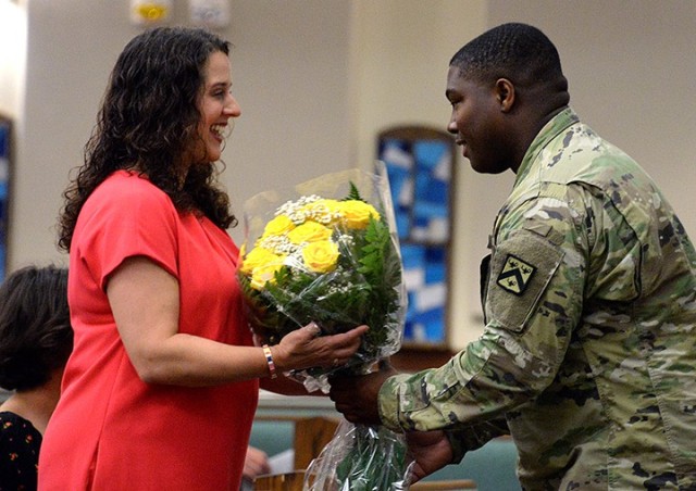 Jenn Babich, spouse of incoming Mission Command Training Program Commander Col. Bryan Babich, is presented flowers by Cpl. Jayshawn Brown, Headquarters, MCTP, during the MCTP assumption of command ceremony July 23 at Frontier Chapel. Photo by...