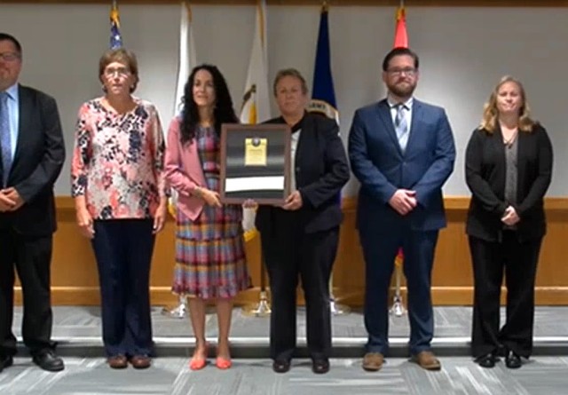Ms. Mary Isrow (Director, Continuous Improvement) accepts the 2020 Lean Six Sigma Excellence for an Enterprise Level Process Improvement Project on behalf of U.S. Army Materiel Command, Tank Automotive and Armaments Command.