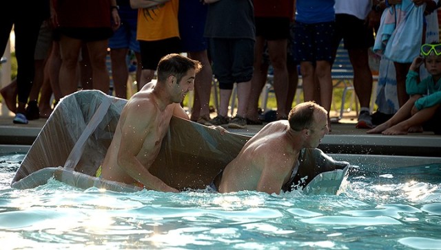 School of Advanced Military Studies students Maj. Jeremy Dixon and Maj. Luke King of Seminar 4 attempt to right their boat as it begins to capsize in the first heat of the SAMS Boatyard Warz races July 22 at Hancock Pool. Photo by Prudence...
