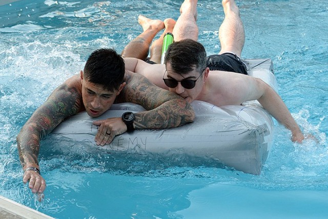 School of Advanced Military Studies students Maj. Teodoro Garcia and Maj. Aaron Phillips maneuver their watercraft toward the pool edge to turn around and complete the lap to secure victory in the final race of the SAMS Boatyard Warz competition...