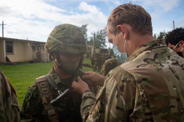 BARRIGADA, Guam – A U.S. Army Green Beret with 1st Battalion, 1st Special Forces Group (Airborne), pins U.S. Jump Wings on a member of the Japan Ground Self-Defense Force during a wing exchange ceremony held July 31, 2021. Airborne personnel...