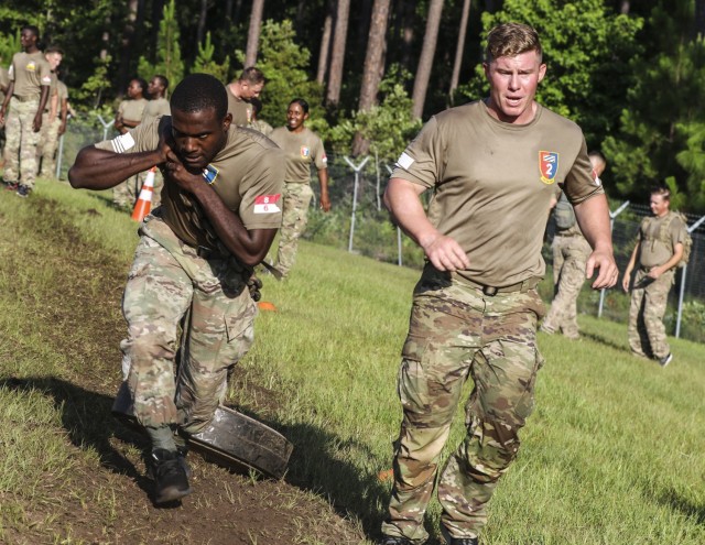 Soldiers with 6th Squadron, 8th Cavalry Regiment, 2nd Armored Brigade Combat Team, 3rd Infantry Division, drag a 80-pound M1A1 Main Battle Tank road wheel during an Iron Spartan competition on Fort Stewart June 25, 2021. The comprehensive, timed...