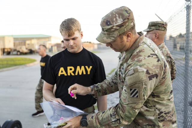 The Dead Lift Chipper lane officer-in-charge stamps a company commander's paper validating successful completion of the lane part of the larger Iron Spartan Competition on Fort Stewart, Georgia, June, 25 2021. The comprehensive, timed competition...