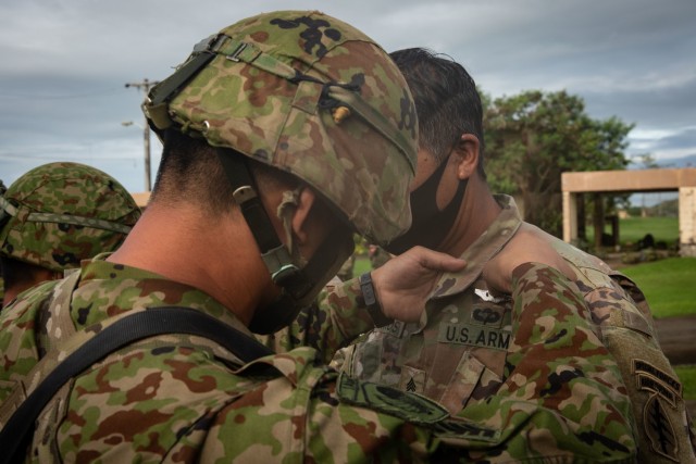 BARRIGADA, Guam – A member of the Japan Ground Self-Defense Force pins Japanese Jump Wings on a U.S. Army Green Beret assigned to 1st Battalion, 1st Special Forces Group (Airborne), during a wing exchange ceremony July 31, 2021. Airborne...