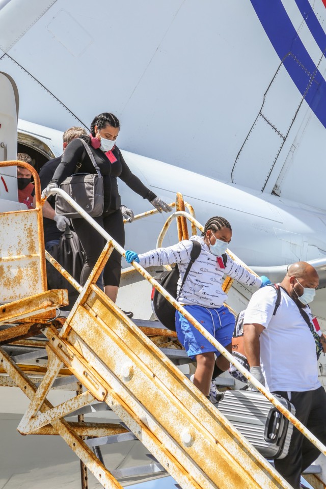 Staff Sgt. Effie Banks, top left, disembarks from an ATI flight at Bucholz Army Airfield on U.S. Army Garrison-Kwajalein Atoll in April 2021.