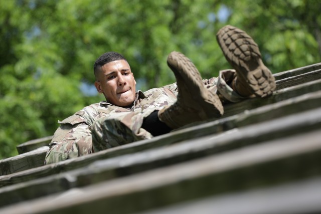 Spc. Christian Kerkado-Colon maneuvers across wooden beams during an obstacle course at the Army Materiel Command Best Warrior Competition in Camp Atterbury, Ind. July 25-28. Kerkado-Colon was named AMC’s Soldier of the year.  (U.S. Army photo by Eben Boothby) 
