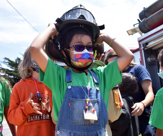Makena Matias, a Bear who belongs to Cub Scout Pack 451 in Turlock, tries on a firefighter’s helmet during the Monterey Cub Scout Camp at the Presidio of Monterey, Calif., July 29.