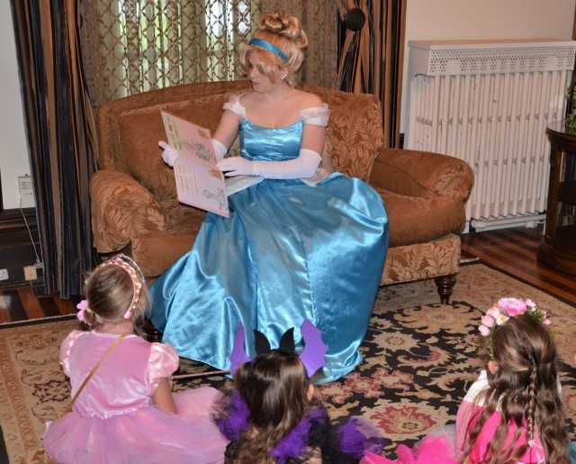 Cinderella (Gabriella Goderis) shares a story with some mini-princesses at the “Storytime with Princesses” event held at Rock Island Arsenal, Illinois, July 17.