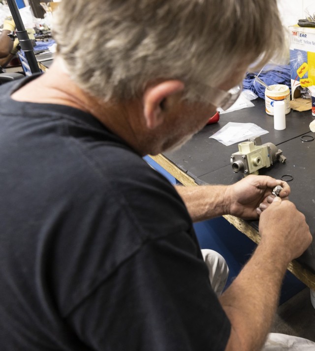 Bubba Hughes, artillery mechanic, cleans a valve part in preparation for a new O-ring at Anniston Army Depot.