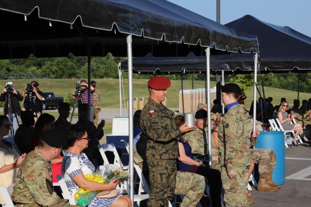 FORT KNOX, Ky - Polish Maj. Gen. Adam Joks (left), the incoming V Corps Deputy Commanding General of Interoperability, accepts a ceremonial artillery shell casing from Sgt. Carli Riley, executive assistant to the senior enlisted advisor, V Corps, during a welcome ceremony. The Victory Corps welcomed Joks and Brig. Gen. Matthew Van Wagenen, newly arrived V Corps Deputy Commanding General of Maneuver, to the V Corps team during the ceremony August 4, 2021, at Fort Knox. (U.S. Army photo by Pvt. Gabriella Sullivan, Mass Communications Specialist V Corps)