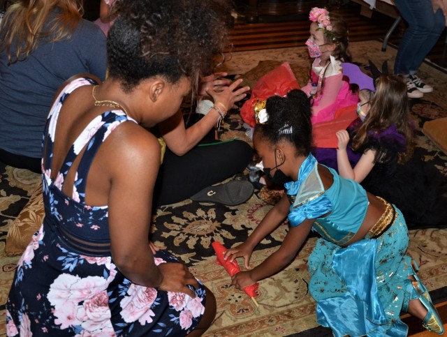 “Queen” April Matthews and daughter, Princess Naomi, work on their paper rose activity at the “Storytime with Princesses” event hosted by FMWR at Rock Island Arsenal, Illinois, July 17.