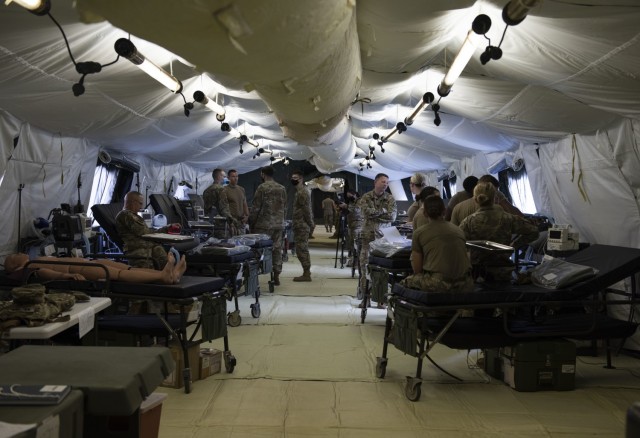Soldiers from the 311th Field Hospital from Blacklick, Ohio, relax after setting up a 32-bed hospital during an Army field exercise at Yokota Air Base, Japan, June 25, 2021. During the exercise, the soldiers performed a variety of simulated procedures to include installing IVs, providing sutures and opening airways. (U.S. Air Force photo by Senior Airman Hannah Bean)