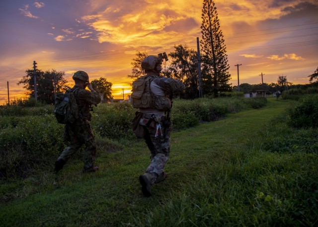 BARRIGADA, Guam -- A Green Beret assigned to 1st Battalion, 1st Special Forces Group (Airborne), maneuvers to the objective area alongside a member of the Japan Ground Self-Defense Force during Defender Pacific 21 on July 30, 2021. DP21 is one of...