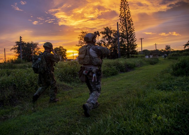 BARRIGADA, Guam -- A Green Beret assigned to 1st Battalion, 1st Special Forces Group (Airborne), maneuvers to the objective area alongside a member of the Japan Ground Self-Defense Force during Defender Pacific 21 on July 30, 2021. DP21 is one of many U.S. Army Pacific exercises and activities occurring during summer 2021 which implements the National Defense Strategy by integrating Land Power in the Indo-Pacific to enable the Joint Force; build trust and interoperability with allies and partners; and employ emerging multi-domain capabilities to support innovation and experimentation. (U.S. Army photo by Spc. GaoZong Lee) (This photo has been altered for security purposes.)