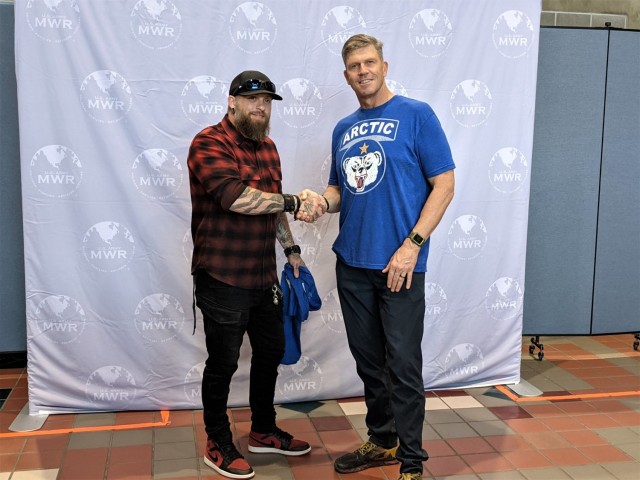 Maj. Gen. Peter Andrysiak, US Army Alaska commanding general, presents a unit coin and t-shirt to country singer Brantley Gilbert before Fort Wainwright's summer concert June 5. The outdoor concert featured performances by rapper and movie star...