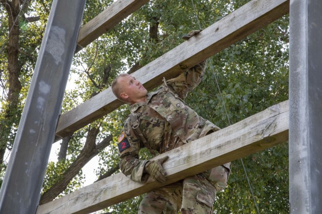 U.S. Army Sgt. Hunter Wilson, a noncommissioned officer assigned to III Corps, climbs up the  &#34;Confidence Climb&#34; portion of the Obstacle Course event during the 2021 FORSCOM Best Warrior Competition, Aug. 2, 2021, at Fort Riley, Kansas....
