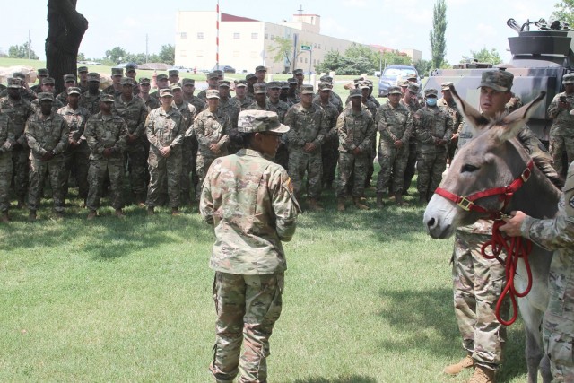 With assistance from handler officer in charge, 2nd Lt. Hadiyah Underwood, center, Sgt. Isaac Sorensen, handler NCOIC, gives a brief history of A Battery’s mascots to Field Artillery Basic Leader Course students.