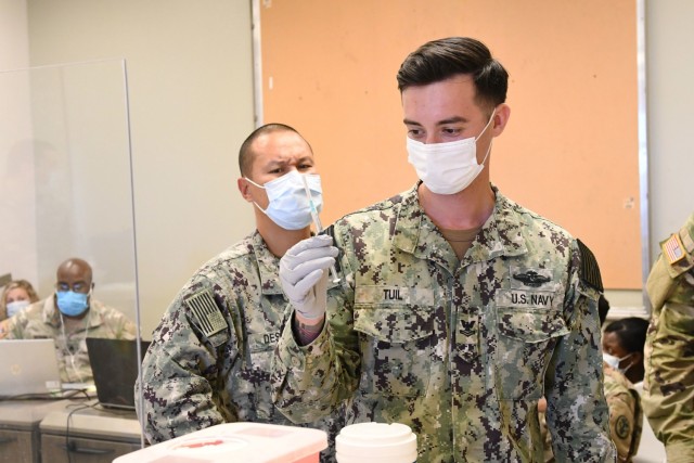 Hospital Corpsman Second Class David Tuil prepares a Pfizer COVID-19 vaccine syringe at a joint-service COVID-19 vaccination event at the Navy Exchange Pearl Harbor, Hawaii on July 16, 2021. The joint-service event was staffed by Hospital Corpsman from Navy Medicine Readiness and Training Command Pearl Harbor and U.S. Army medical staff from Tripler Army Medical Center. The free event kicked off on July 16 and will run for four weekends in July and August from 9 am to 2 pm. All TRICARE beneficiaries, as well as government civilians and non-appropriated fund (NAF) employees are eligible to receive their vaccine at the event.