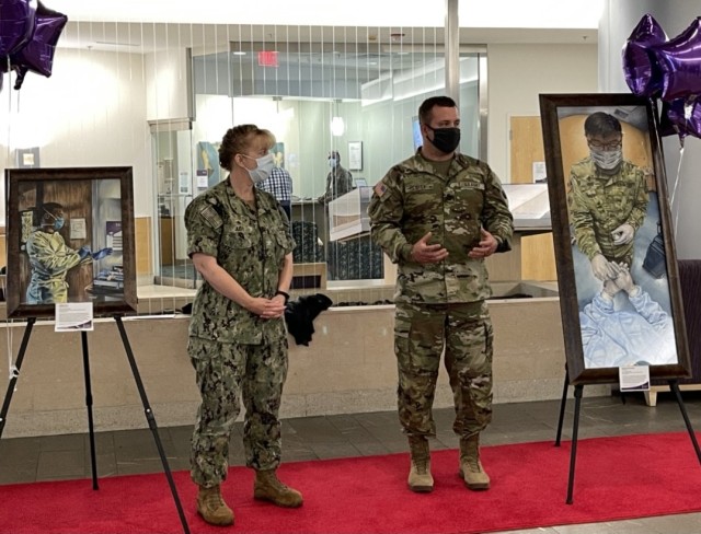 Navy Captain Cynthia Judy and Army Sgt. 1st Class Curt Loter talk about the new COVID-19 artwork at the Fort Belvoir Community Hospital on August 4, 2021.