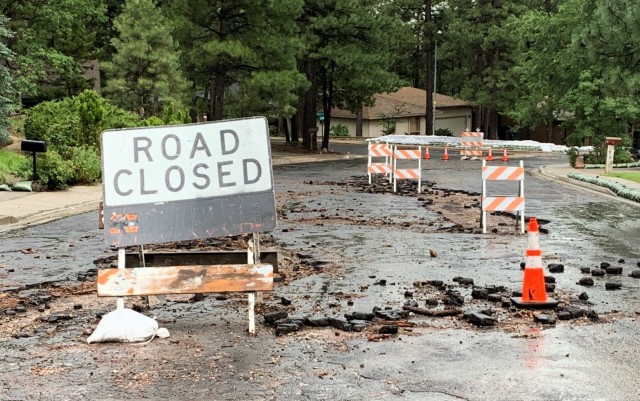 Coconino County and Flagstaff Emergency response units place signs and safety cones along damaged roads to prevent accidents and damage July 30 in Flagstaff, Arizona. Due to the sporadic and heavy rain fall, emergency crews must continuously check...