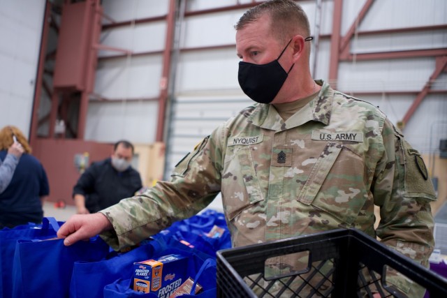JOINT BASE ELMENDORF-RICHARDSON, Alaska -- Command Sgt. Maj. James Nyquist, state command sergeant major for the Alaska Army National Guard, arranges Alaska USO care packages before a Commissary sale Aug. 7, 2021, at the Alaska Army National Guard...