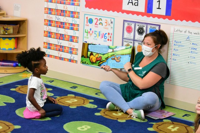 Antoinette Wahl, Child and Youth Program assistant, reads a story to Jaclyn Gowans, 4, before nap time Aug. 11 at Gardner Hills Child Development Center. Wahl used the Civilian Employment Assignment Tool to transfer from a CDC at Fort Bliss, Texas.
