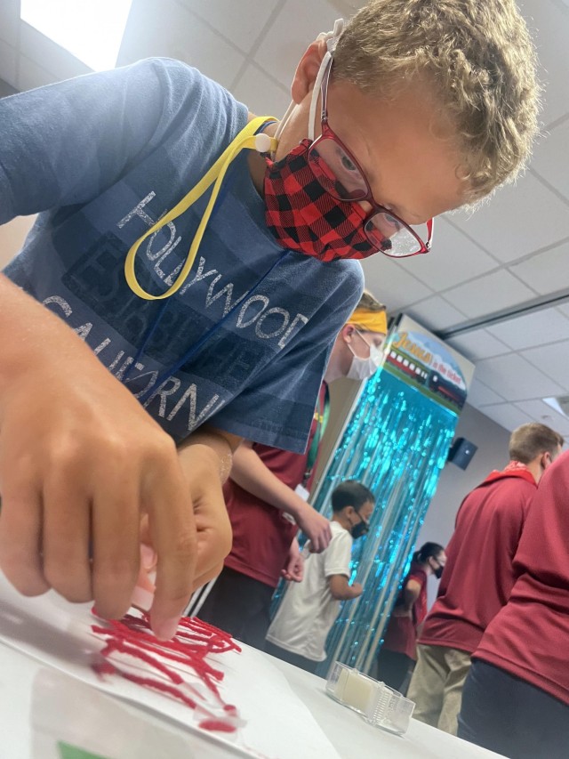 Blake Scott works on creating a railroad out of string during craft time, Aug. 9 at the Four Chaplains Memorial Chapel. The craft also included creating "off-road rollers" which could roll on the tracks.  (Photo by Monica K. Guthrie)