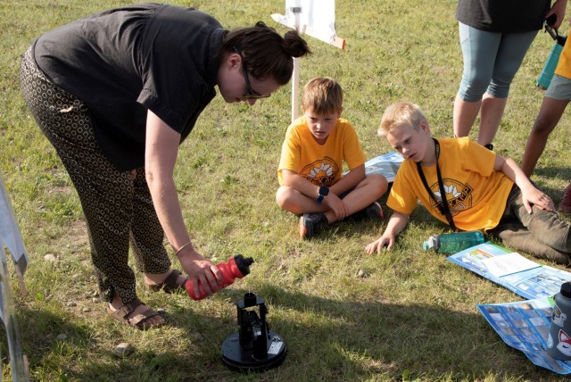 Students watch Lauren Oliver, hydraulics and hydrology engineer with the U.S. Army Corps of Engineers – Alaska District, demonstrate a tipping bucket rainwater gauge on Aug. 5 at the Chena River Lakes Flood Control Project near North Pole,...