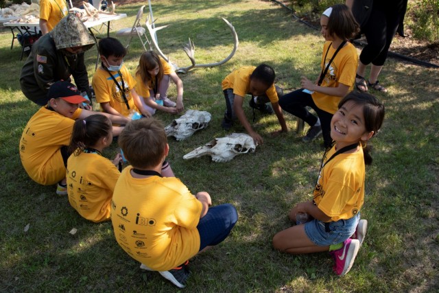 Campers examine moose skulls with Ranna Wells, zooarcheologist with the U.S. Army Corps of Engineers – Alaska District, on Aug. 5 at the Chena River Lakes Flood Control Project near North Pole, Alaska. The students learned how to identify the...