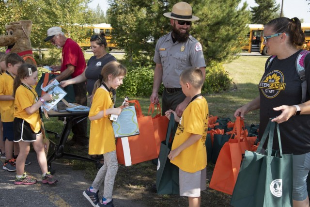 Justin Kerwin, senior park ranger for the U.S. Army Corps of Engineers – Alaska District, and Bobber the Water Safety Dog pass out water safety materials on Aug. 5 at the Chena River Lakes Flood Control Project near North Pole, Alaska. As the...