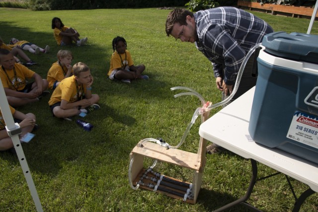 Andrew Romero, geotechnical engineer with the U.S. Army Corps of Engineers – Alaska District, demonstrates how gravel, sand and silt hold water back differently for a group of students during a STEM event on Aug. 5 at the Chena River Lakes Flood...
