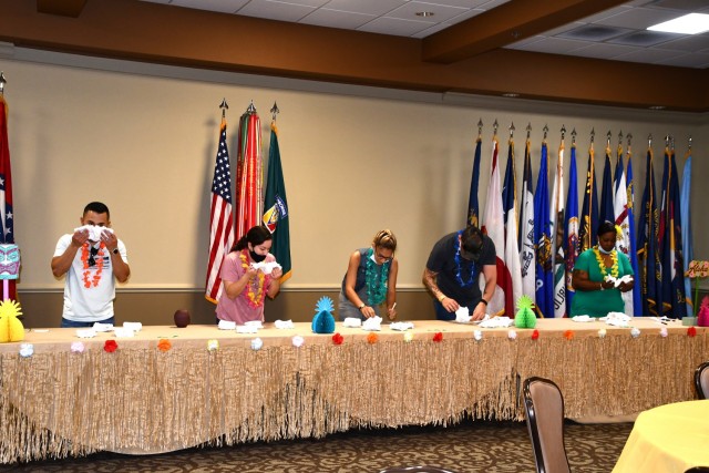 From left to right: Carlos Maysonet, Angelia Cabrera, Rebekah Waibel, Tyler Tyson and Tracey Thompson take part in the diaper poo shower game. Contestants have four diapers with a different kind of melted chocolate candy in each. Participants had to correctly figure out what type of candy bar was in each diaper the fastest to win.