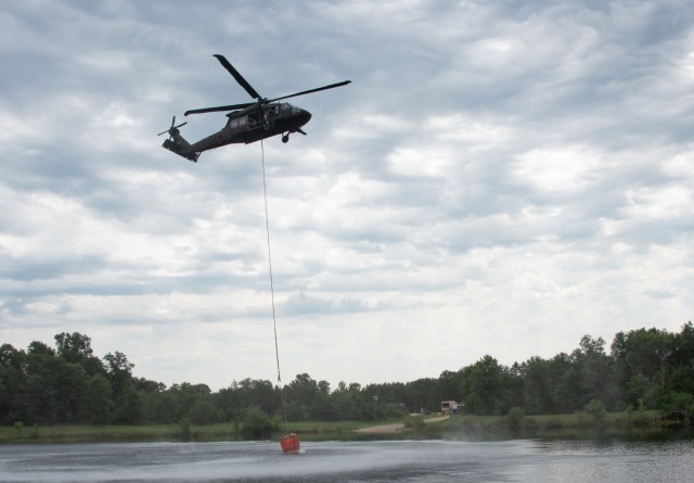 Wisconsin Army National Guard UH-60 Black Hawk crews from the Madison, Wis.-based 1st Battalion, 147th Aviation train to drop water on wildfires using Bambi Buckets at Fort McCoy, Wis., August 12, 2021 in preparation for deployment to California. Two aircraft and 17 troops departed Wisconsin August 13, 2021 to battle wildfires in California. U.S. Army photo by Greg Mason, Fort McCoy Multimedia-Visual Information Office