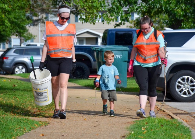 Stonegate community resident and volunteer Oliva McCain (left) picks up trash and storm debris along Montrose Street with fellow residents Vanessa and Elias Ward, during an Aug. 13 community beautification event.