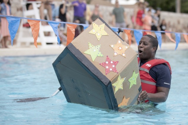 A contestant accepts his fate at the Cardboard Regatta at Fort Bliss, Texas, Aug. 14, 2021. Bliss Family and Morale, Welfare and Recreation held the annual event, which challenged contestants to build two-person vessels out of corrugated cardboard and tape and keep them afloat during racing at the Community Pool on west Bliss.