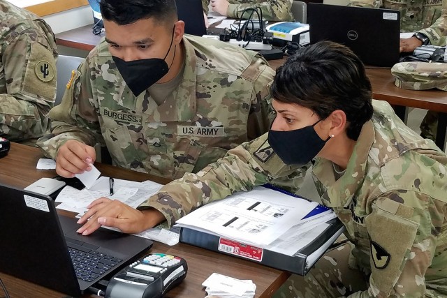 Master Sgt. Eva Miranda, U.S. Army Financial Management Command Operational Support Team senior financial management systems instructor, helps Soldiers use financial management tactical platforms, or FMTPs, during Diamond Saber at Fort McCoy,...