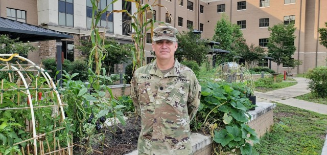 Lt. Col. Jason Carter, a Soldier assigned to the Fort Benning Soldier Recovery Unit, Georgia, posed for a photo in front of the Fort Benning SRU garden where Soldiers grow vegetables, such as potatoes, beans and zucchini. (Photo courtesy of Chaplain Cheonchong Kim)