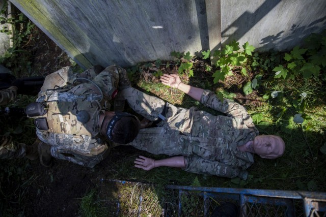 Spc. Jarrett Rodriguez from Desmond Doss Health Clinic participates in the mystery event where participants’ objective was to clear multiple buildings then find, treat and extract a simulated casualty during the Regional Health...