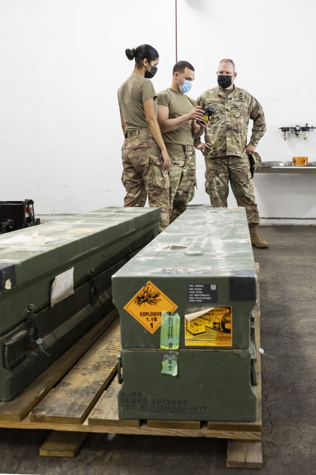 Brig. Gen. Jeffrey W. Jurasek (right) observes Spc. Diego Torres (center) and Spc. Glissette Fox (left) inventory munitions using a radio frequency device.
