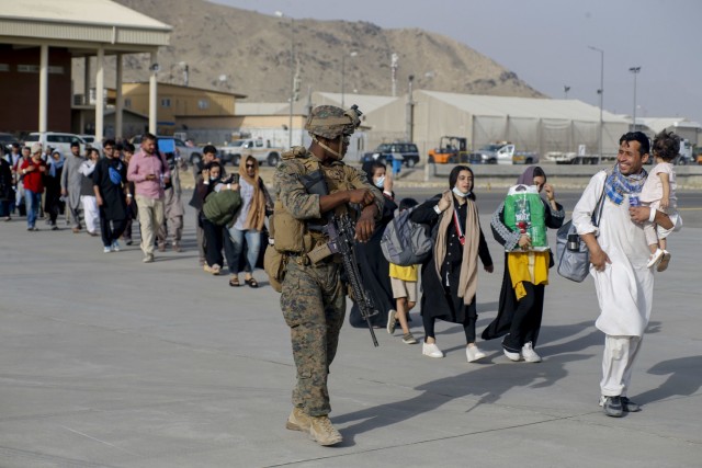 210818-M-JM820-1162 HAMID KARZAI INTERNATIONAL AIRPORT, Afghanistan (August 18, 2021) – U.S. Marines assigned to 24th Marine Expeditionary Unit escorts evacuees during an evacuation at Hamid Karzai International Airport, Afghanistan, Aug. 18. U.S. service members are assisting the Department of State with an orderly drawdown of designated personnel in Afghanistan. (U.S. Marine Corps photo by Lance Cpl. Nicholas Guevara)